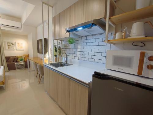 a kitchen with a sink and a microwave at Cozy Studios at Inspiria Condo Davao City beside Abreeza Mall in Davao City