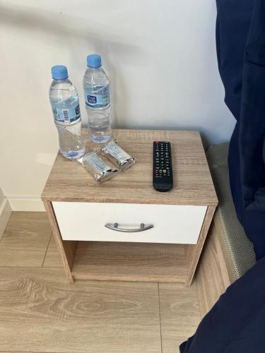 due bottiglie d'acqua e un telecomando sul comodino di Habitación confortable para parejas (1) a Barcellona