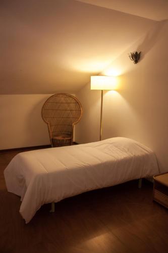 1 dormitorio con 1 cama con lámpara y silla en Palácio da Quinta da Portela IV, en Coímbra