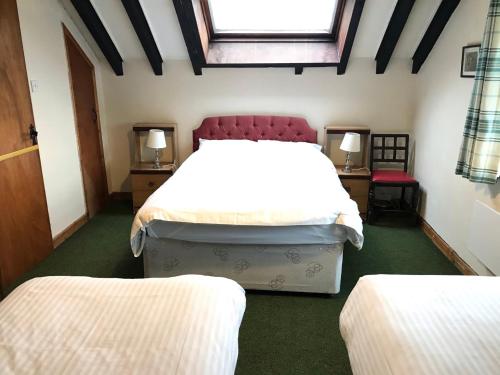 una camera con due letti e due tavoli e una finestra di Cottage on Exmoor - Sleeps 8 & Parking a Minehead