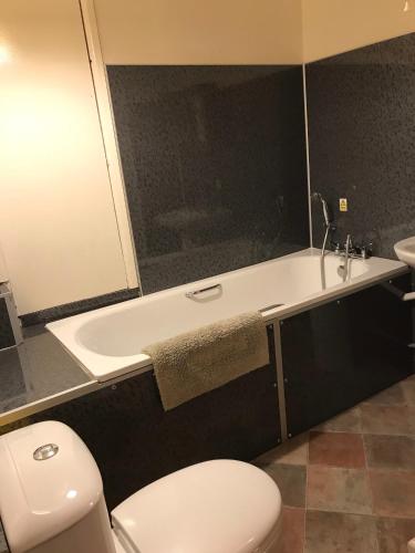 a bathroom with a toilet and a tub and a sink at Cottage on Exmoor - Sleeps 8 & Parking in Minehead