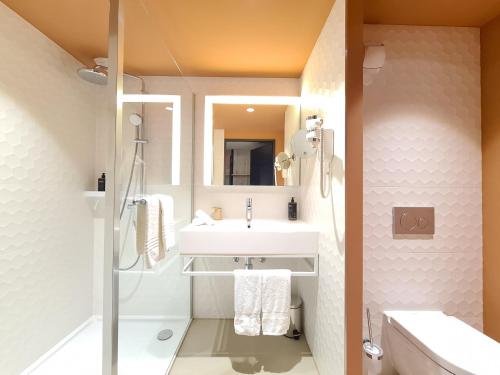 uma casa de banho com um lavatório e um chuveiro em Mercure Hotel Delémont em Delémont