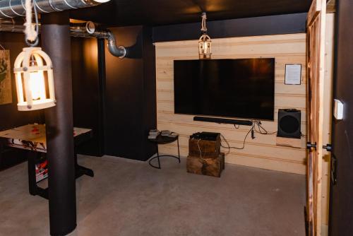 a living room with a large television in a wall at NOVMI - Domki letniskowe 