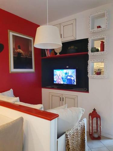 a living room with red walls and a tv at Casa Magnolia in Varese
