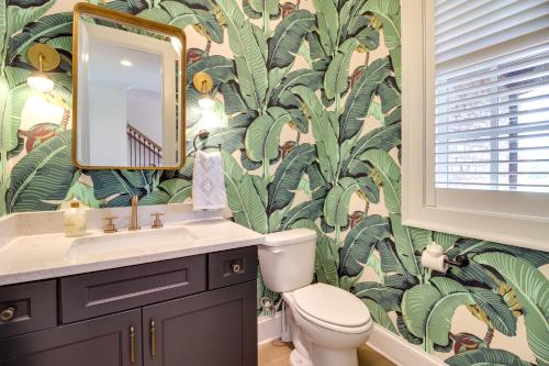 a bathroom with a toilet and a sink with a tropical wallpaper at Charming Savannah Townhome - 1 Block to Riverwalk! in Savannah