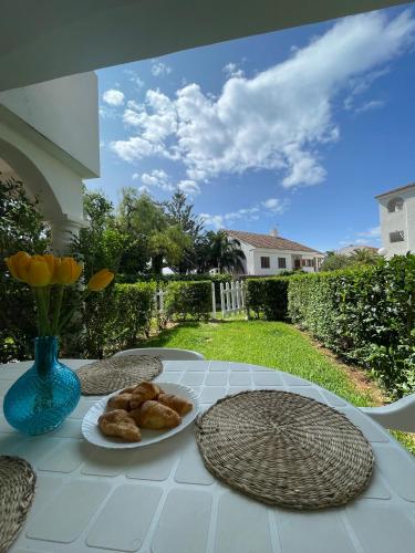 a table with a plate of food and a vase with flowers at APCOSTAS - Complejo Al Andalus in Alcossebre