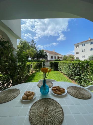 a table with plates of food and a vase of flowers at APCOSTAS - Complejo Al Andalus in Alcossebre