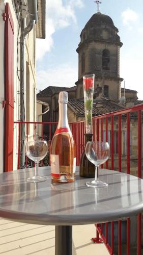 - une table avec 2 verres et une bouteille de vin sur le balcon dans l'établissement Bel appartement au coeur de la cité médiévale, à Sommières