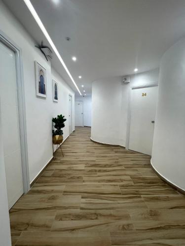 an office corridor with white walls and wooden floors at HOSTAL MH BORJ in Martil