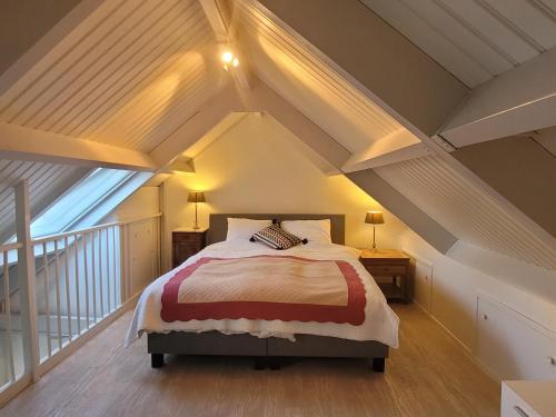 ein Schlafzimmer mit einem Bett im Dachgeschoss in der Unterkunft De Appelpit in Veere