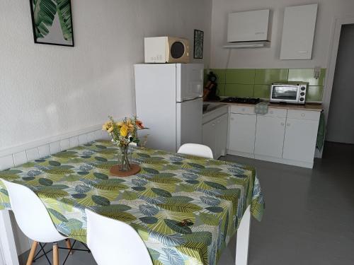 a kitchen with a table with a vase of flowers on it at Gite Duguesclin in La Flocellière