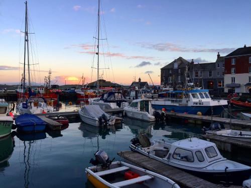 a group of boats docked in a marina at sunset at Coastal retreat surrounded by open countryside in Saint Ervan