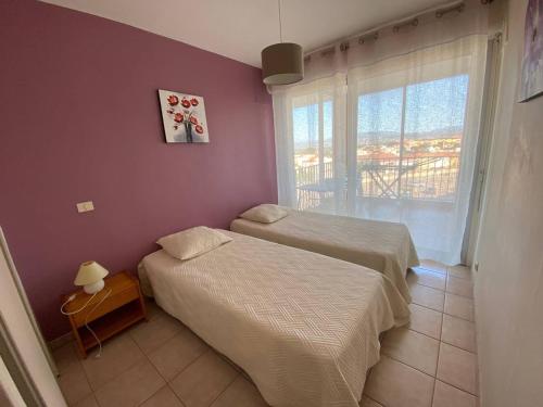 - une chambre avec 2 lits et une fenêtre avec vue dans l'établissement Duplex T3 6 personnes avec terrasse, BBQ et parking, près de la plage - FR-1-81-496, au Barcarès