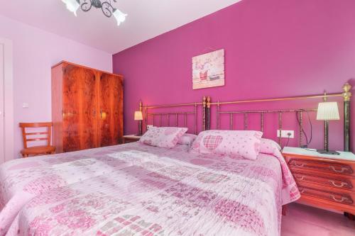sypialnia z fioletowymi ścianami i dużym łóżkiem w obiekcie Barranco de las Maravillas w mieście Teruel