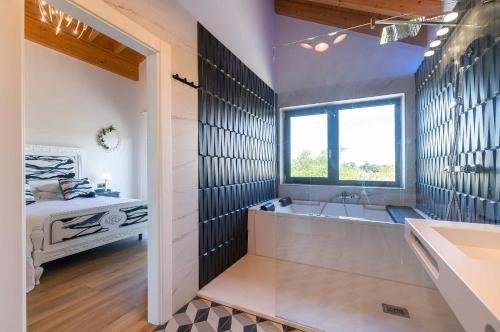 a bathroom with a tub and a sink and a bed at Villa Vacacional La Raizona in Pancar