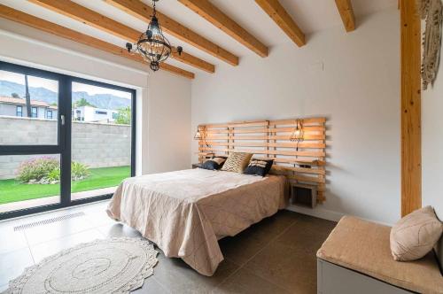 a bedroom with a bed and a large window at Villa Vacacional La Raizona in Pancar