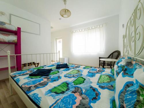 a bedroom with a bed with a blue and white comforter at OZ Vama Veche in Vama Veche