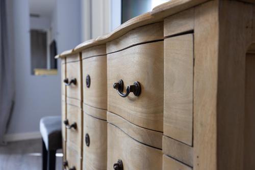 a wooden cabinet with drawers in a room at Hôtel-Restaurant des Augustins in Saint-Cyprien
