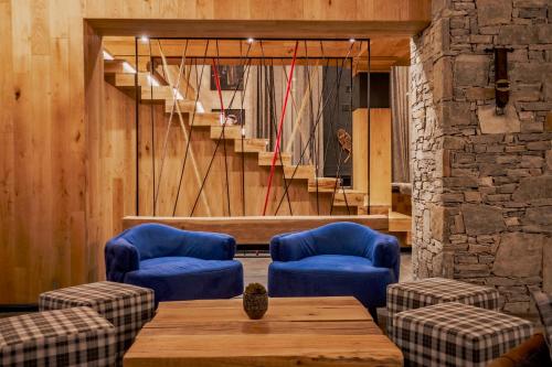a room with two blue chairs and a table and stairs at Kashmir Wellness & SPA Hotel Adults Only in Velingrad