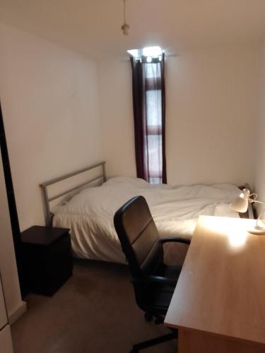 ein Schlafzimmer mit einem Bett, einem Stuhl und einem Schreibtisch in der Unterkunft Apartment Liverpool in Liverpool