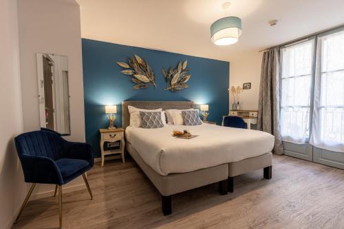een slaapkamer met een groot bed en een blauwe muur bij Hotel-Restaurant des Augustins - Cosy Places by CC - Proche Sarlat in Saint-Cyprien