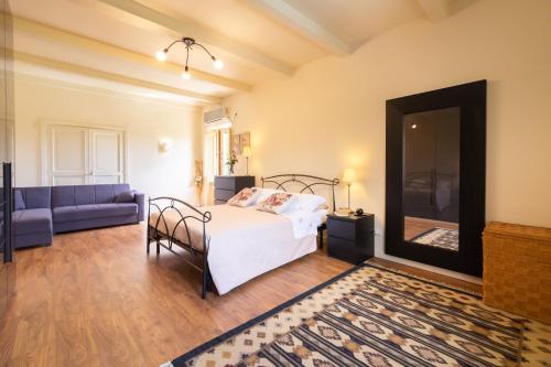 a bedroom with a bed and a blue couch at Villa La Passione Charme House in Venarotta