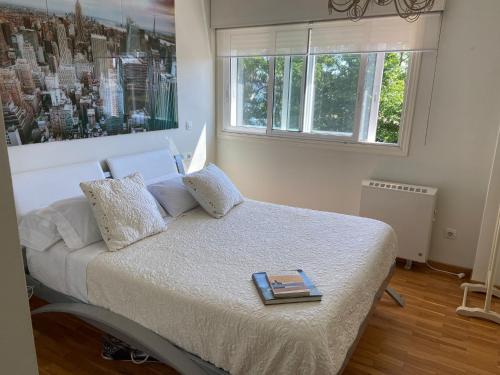 Un dormitorio con una cama con un libro. en Casa Javson en A Coruña