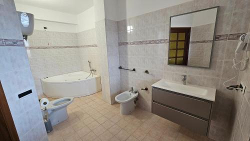 a bathroom with a sink and a toilet and a tub at B&B Da Kociss in Mileto