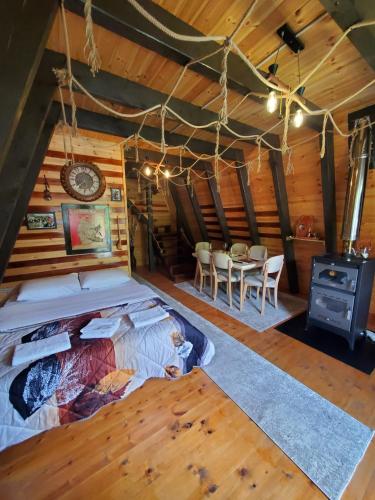 a bedroom in a log cabin with a bed and a table at Vilat Pllumaj in Gropat e Selcës