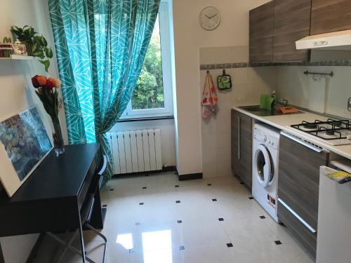 uma cozinha com um lavatório e uma máquina de lavar roupa em Chez Christine la petite em Cogoleto