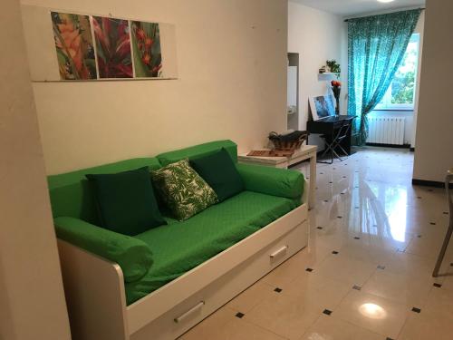 um sofá verde sentado numa sala de estar em Chez Christine la petite em Cogoleto