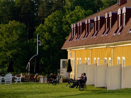 a couple of people sitting in chairs in front of a building at Körunda Golf & Conference Hotel in Ösmo