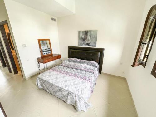 een slaapkamer met een bed, een spiegel en een tafel bij Bahia d el cabo in Cabo Negro