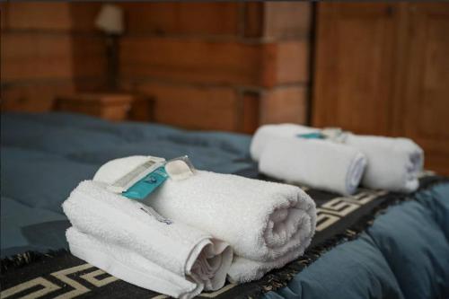 una pila de toallas sentadas encima de una cama en Cabañas del Peñon 3 - 1 dorm en La Cumbrecita