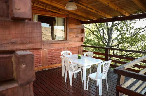 una mesa y sillas en la cubierta de una cabina en Cabañas del Peñon 3 - 1 dorm en La Cumbrecita