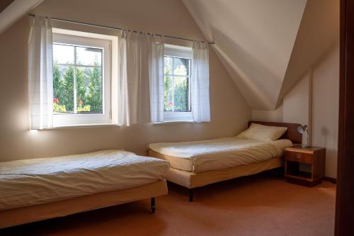 two beds in a room with two windows at Willa Świerkowa in Dębina
