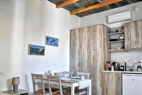 a dining room with a wooden table and chairs at Sea-View Rooftop Terrace Studio in Pánormos