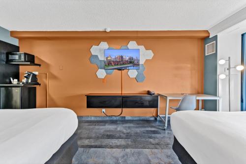 a hotel room with two beds and a desk at Buffalo Airport Hotel in Cheektowaga