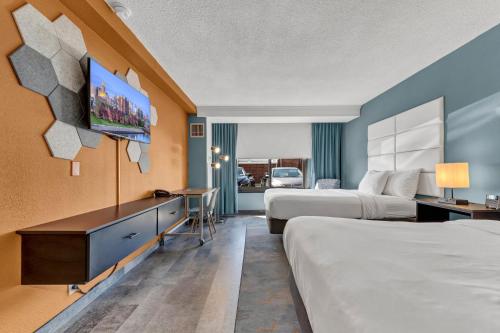 Habitación de hotel con 2 camas y TV de pantalla plana. en Buffalo Airport Hotel en Cheektowaga