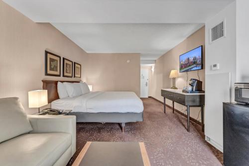 a hotel room with a bed and a couch at Buffalo Airport Hotel in Cheektowaga
