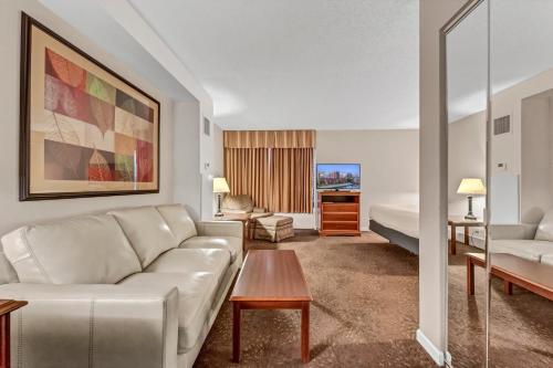 a living room with a couch and a bed at Buffalo Airport Hotel in Cheektowaga