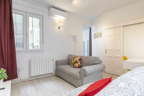 uma sala de estar com um sofá e uma cama em Apartamento céntrico y confortable em Madri