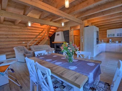 een keuken en eetkamer met een tafel en stoelen bij Miodowa Chata in Brenna