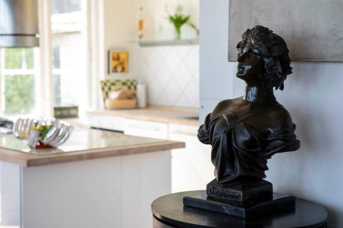 a statue of a woman sitting on a table in a kitchen at Historical beachhouse in Snekkersten in Snekkersten