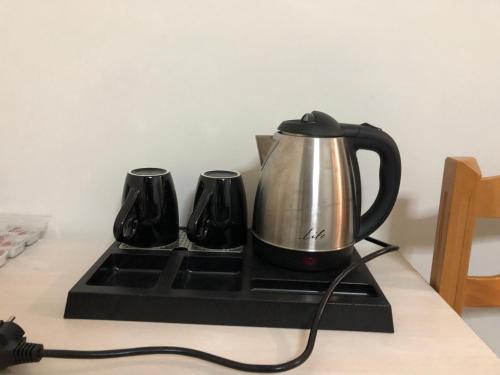a tea kettle on a stove with two cups at MARIAS APARTMENT SMART KEY BOX by PROJECT 86 IKE in Agrinio