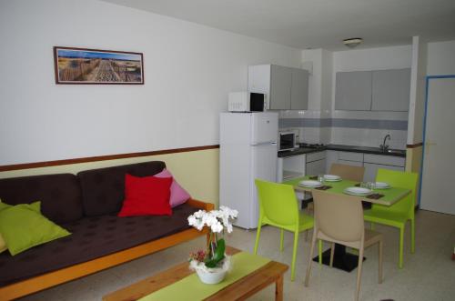 un salon avec un canapé et une table et une cuisine dans l'établissement Village Club Thalassa, à Mèze