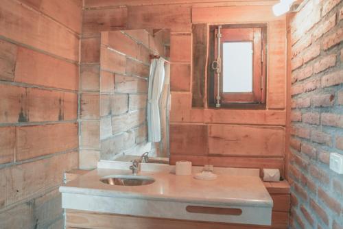 baño con lavabo y pared de ladrillo en Cabañas del Peñon 4 - 1 dorm en La Cumbrecita