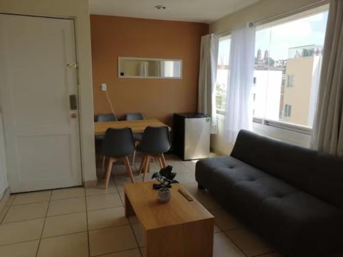 uma sala de estar com um sofá e uma mesa em Departamento Ledu 204 em Morelia
