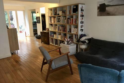 un salon avec un canapé et une étagère dans l'établissement Apartment with garden near Montmartre, à Paris