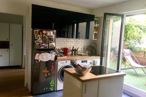 une cuisine avec un réfrigérateur et un lave-vaisselle dans l'établissement Apartment with garden near Montmartre, à Paris